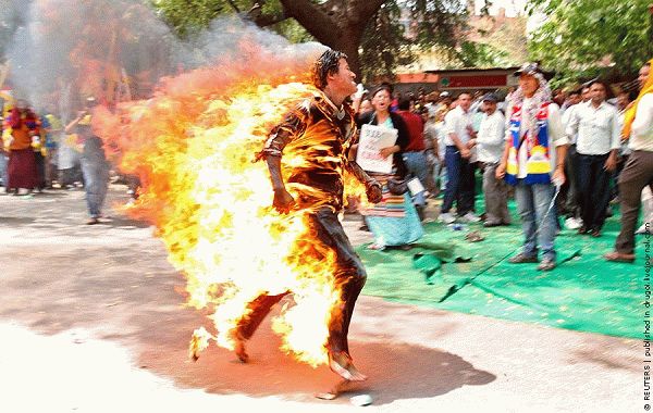 A Tibetan exile runs after setting himself on fire during a protest against the upcoming visit of Chinese President Hu in New Delhi